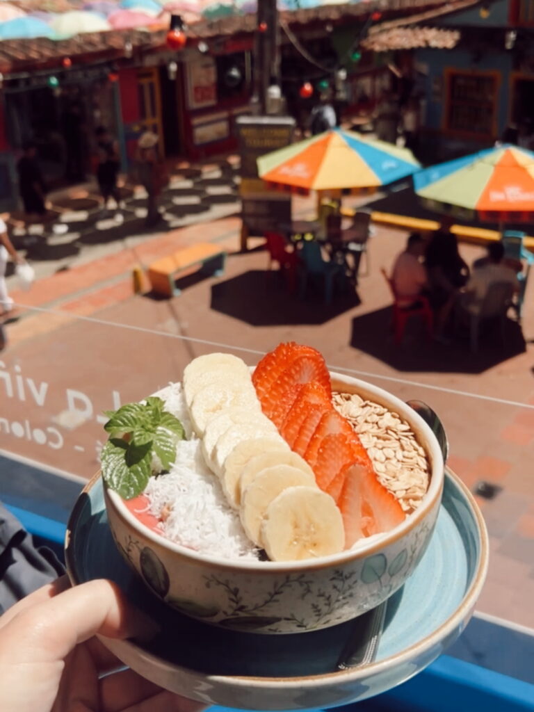 Yogurt bowl on a balcony at Café Arte y Zócalo overlooking colourful streets in Guatape