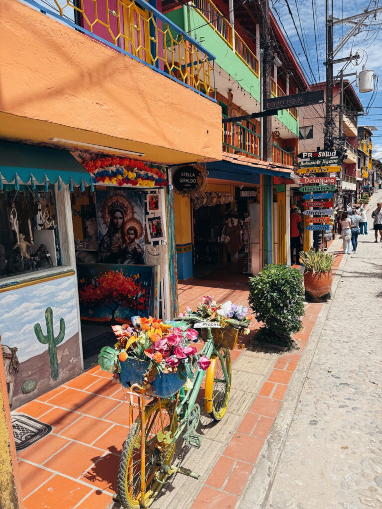 Colourful streets of Guatape with rainbow-painted buildings and decorative umbrellas overhead