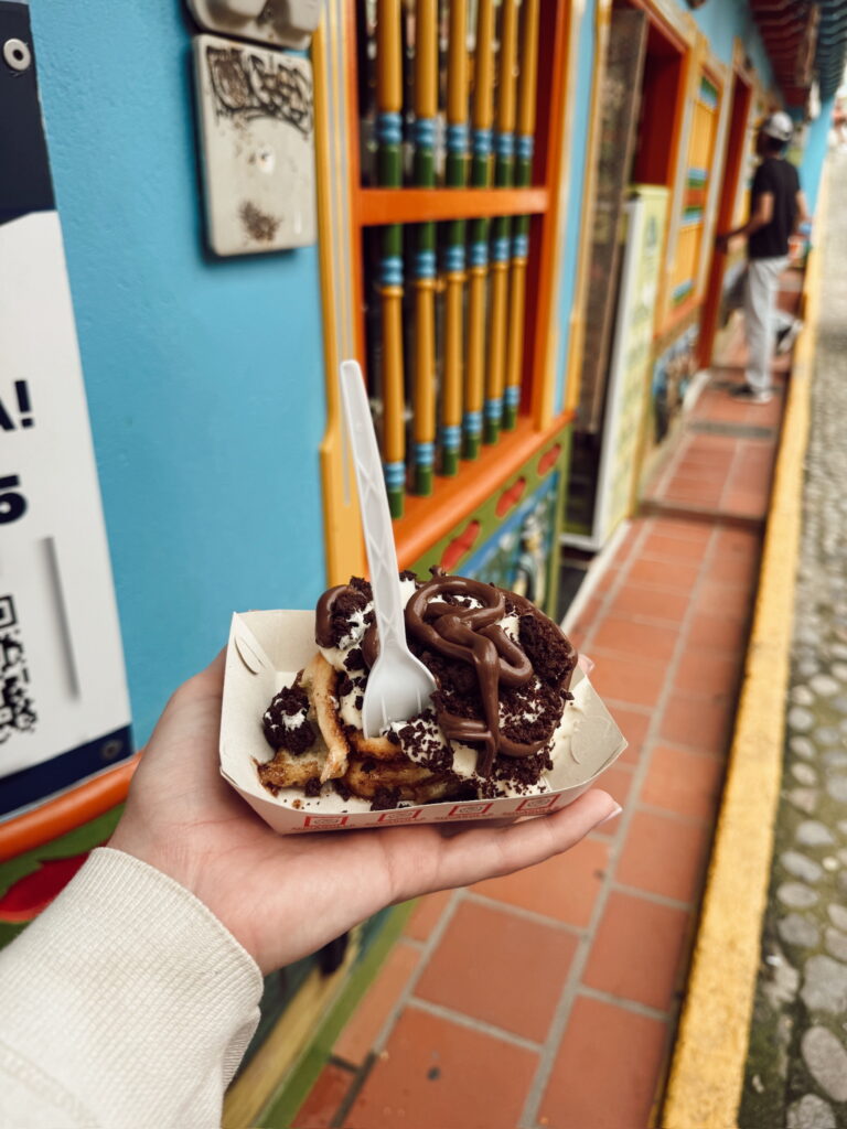 Nutella and cookies cinnamon bun held up on Calle de Recuerdo in Guatape