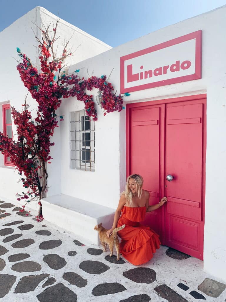 Katie, creator of Where Katie Goes travel blog for women, standing in front of a floral shop in Greece