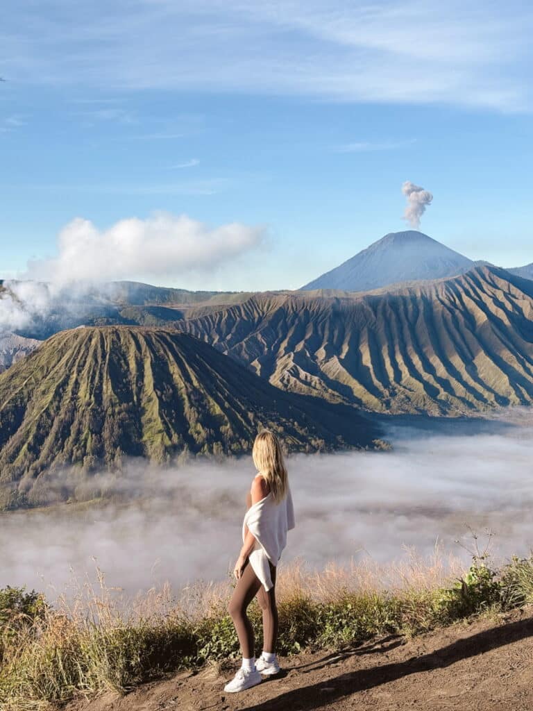 Katie, founder of Where Katie Goes, standing in front of Mount Bromo at sunrise in Java, Indonesia.
