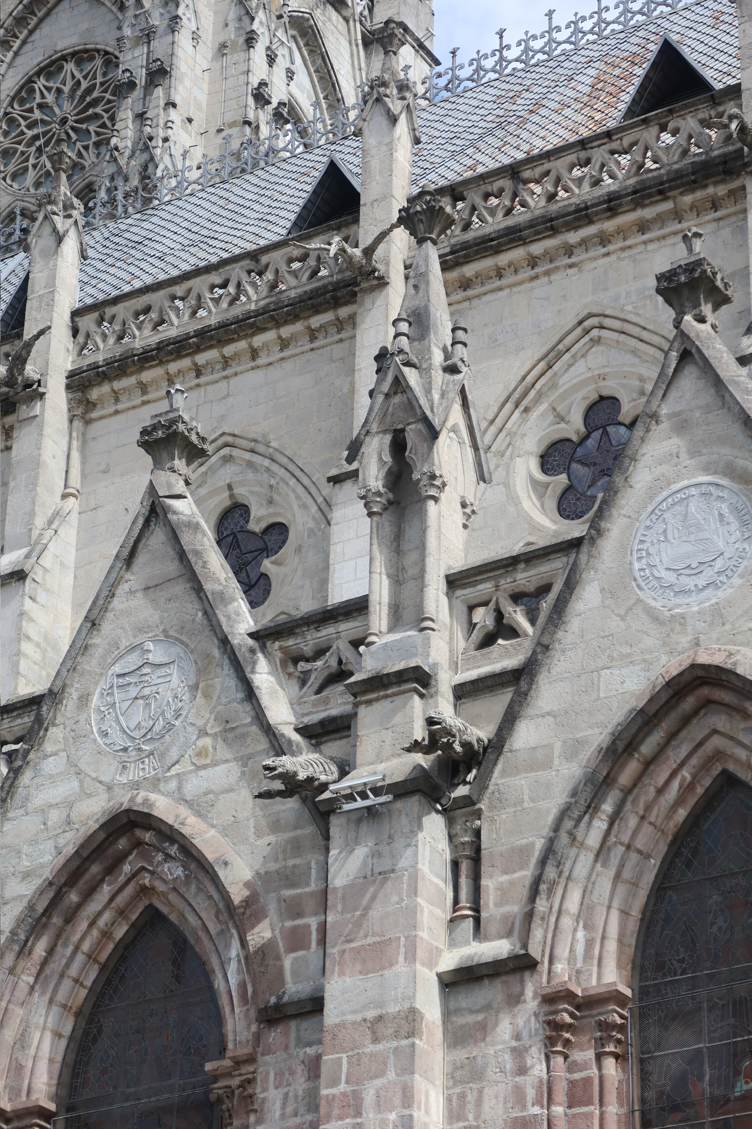 A zoomed in close up shot of the unique stone gargoyle statues carved as native Ecuadorian animals on the exterior of the Basilica church.