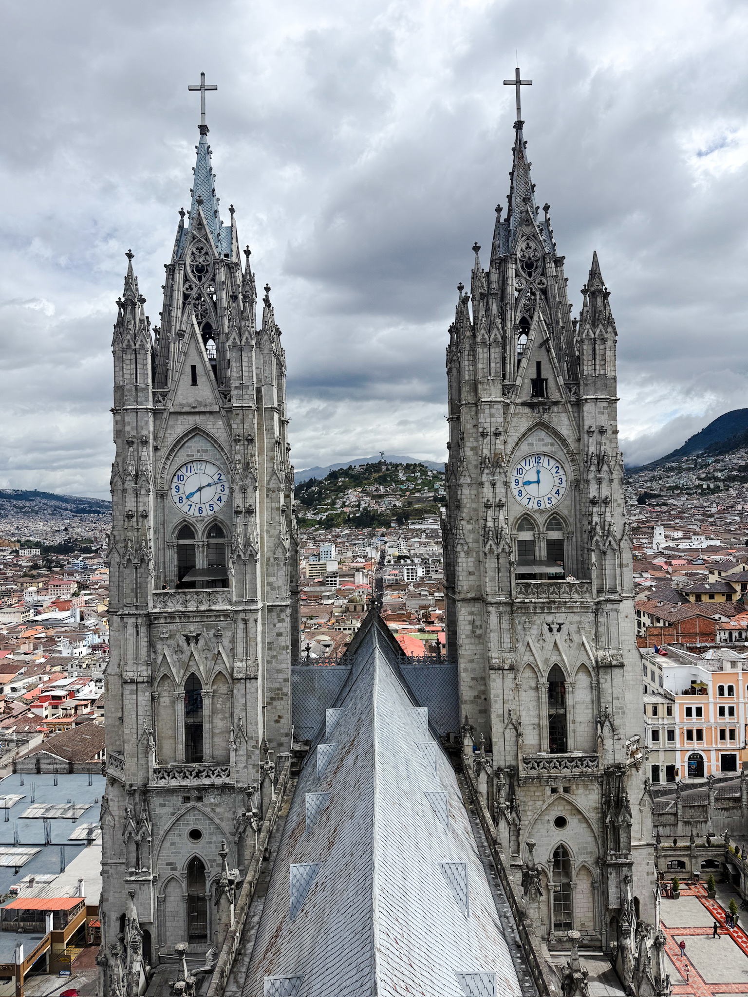Me and Luke posing on a high stone ledge inside the Basilica del Voto Nacional with the 2 giant clock towers rising directly behind us.