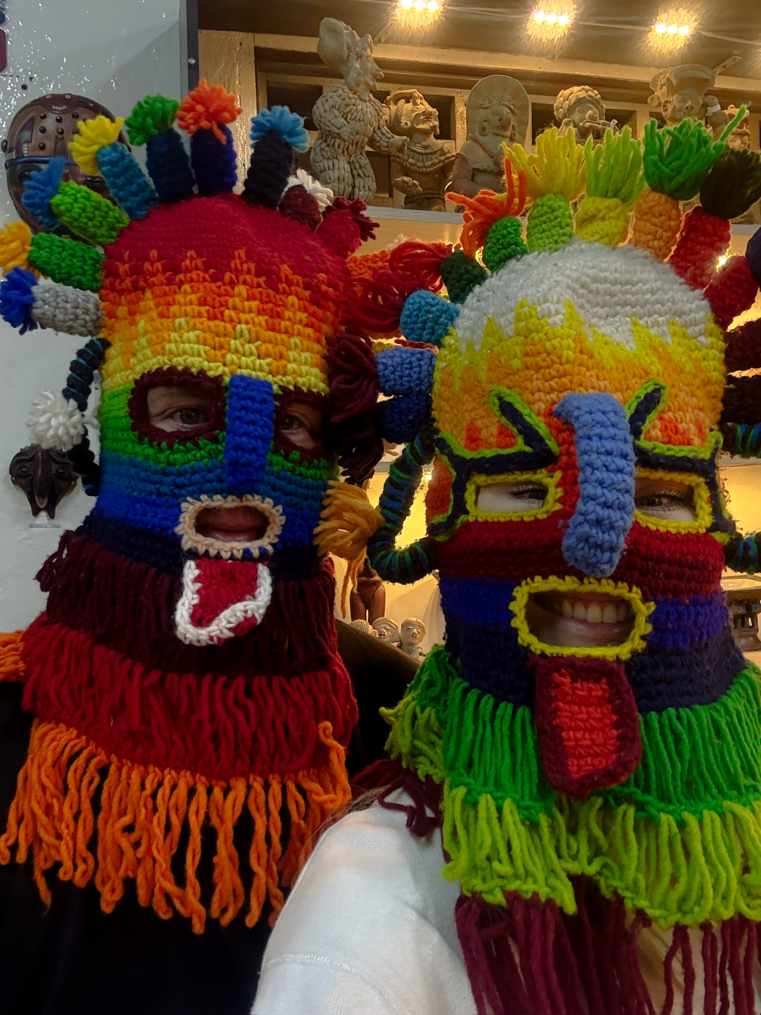 Me and Luke trying on traditional multi colour wooden festival masks during a free walking tour in the historic centre of Quito.